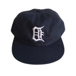 Navy blue unstructured baseball cap with white embroidered backwards Old English “D” on front. Designed by ESP Detroit.