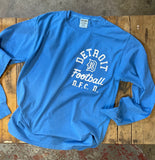 Blue long sleeve t-shirt with white graphic on left chest. From Essential Screen Printing.