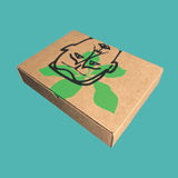 Brown kraft box featuring a graphic leafy face on a turquoise background—part of a limited edition art series.