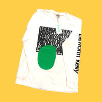 White long sleeve with black and white abstract print, green oval, and text on the sleeve. 